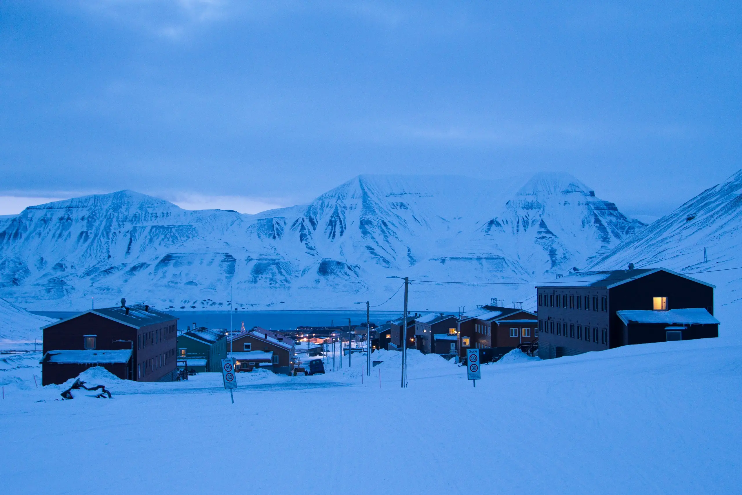 Longyearbyen houses under deep snow in the blue winter dusk
