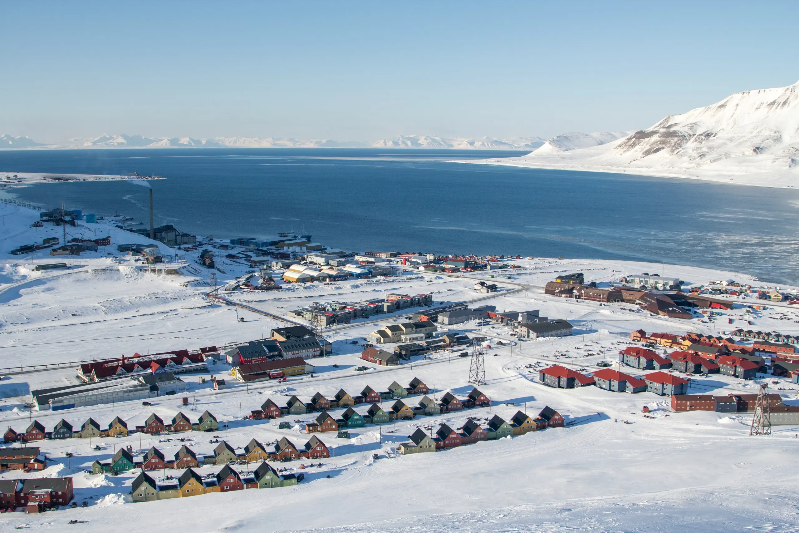 Aerial view of Longyearbyen's colorful cabins beside the fjord