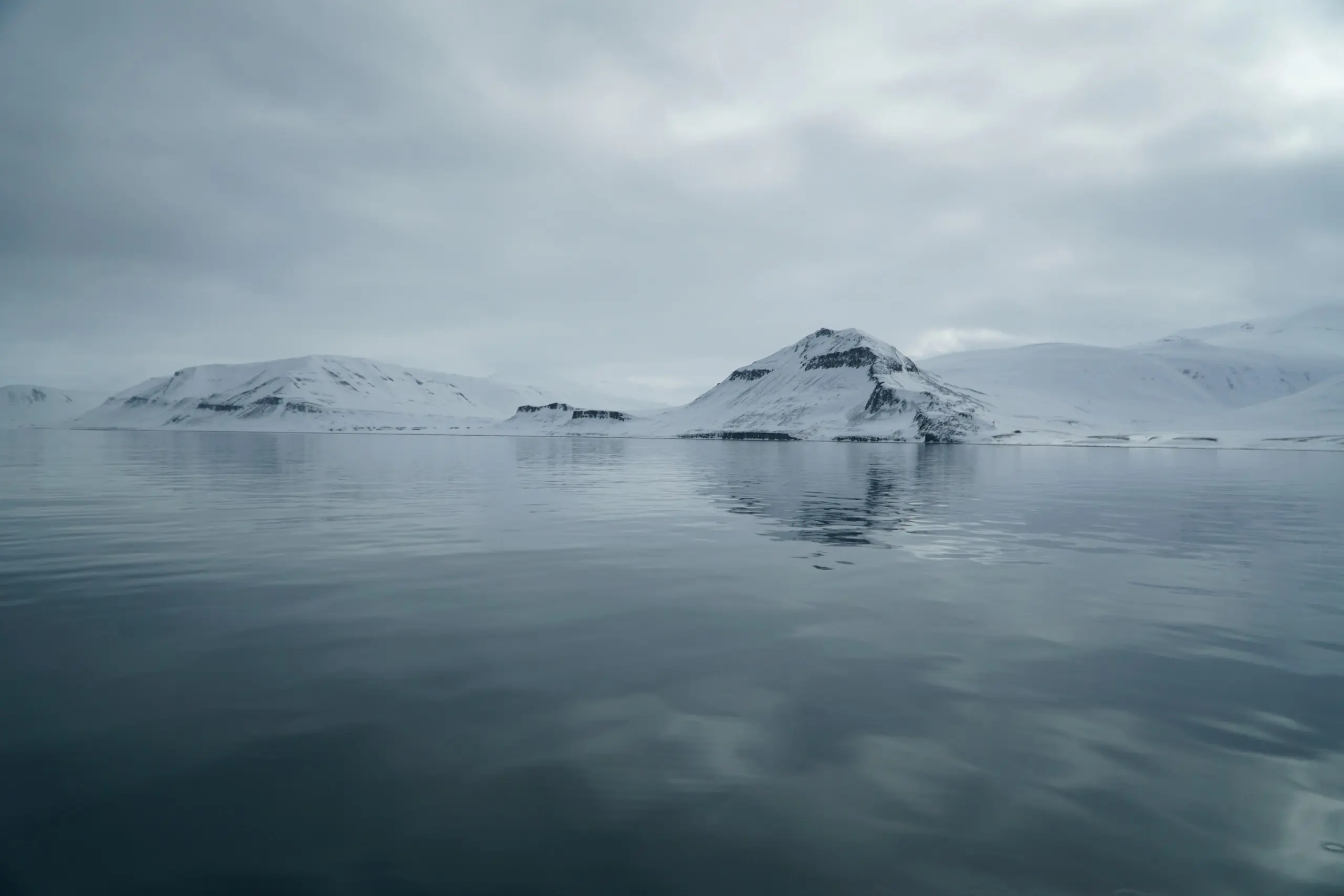 A mirror-calm Svalbard fjord reflecting snowy peaks