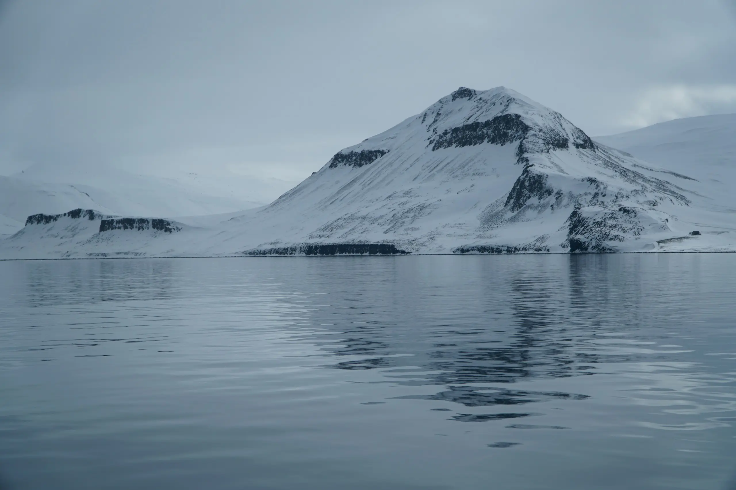 A calm Arctic fjord and distant peaks