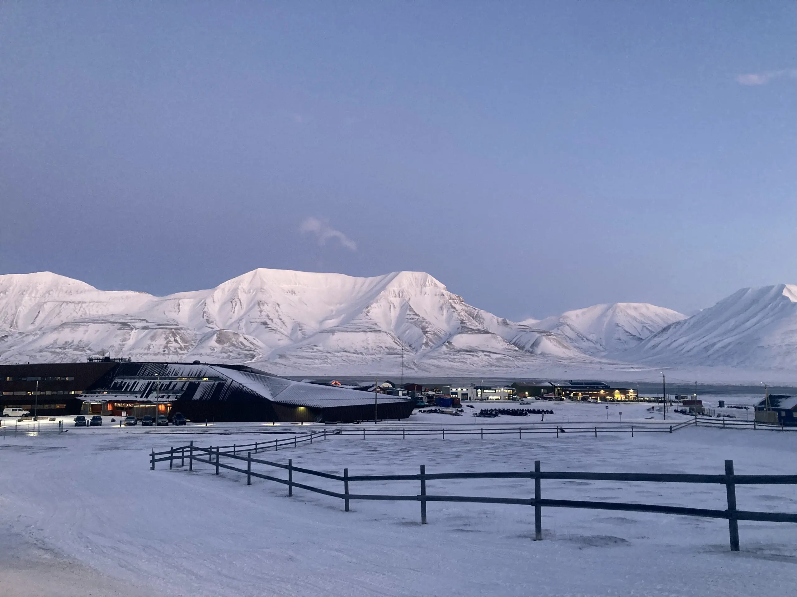 Pink alpenglow on the peaks above Longyearbyen during the light-winter season