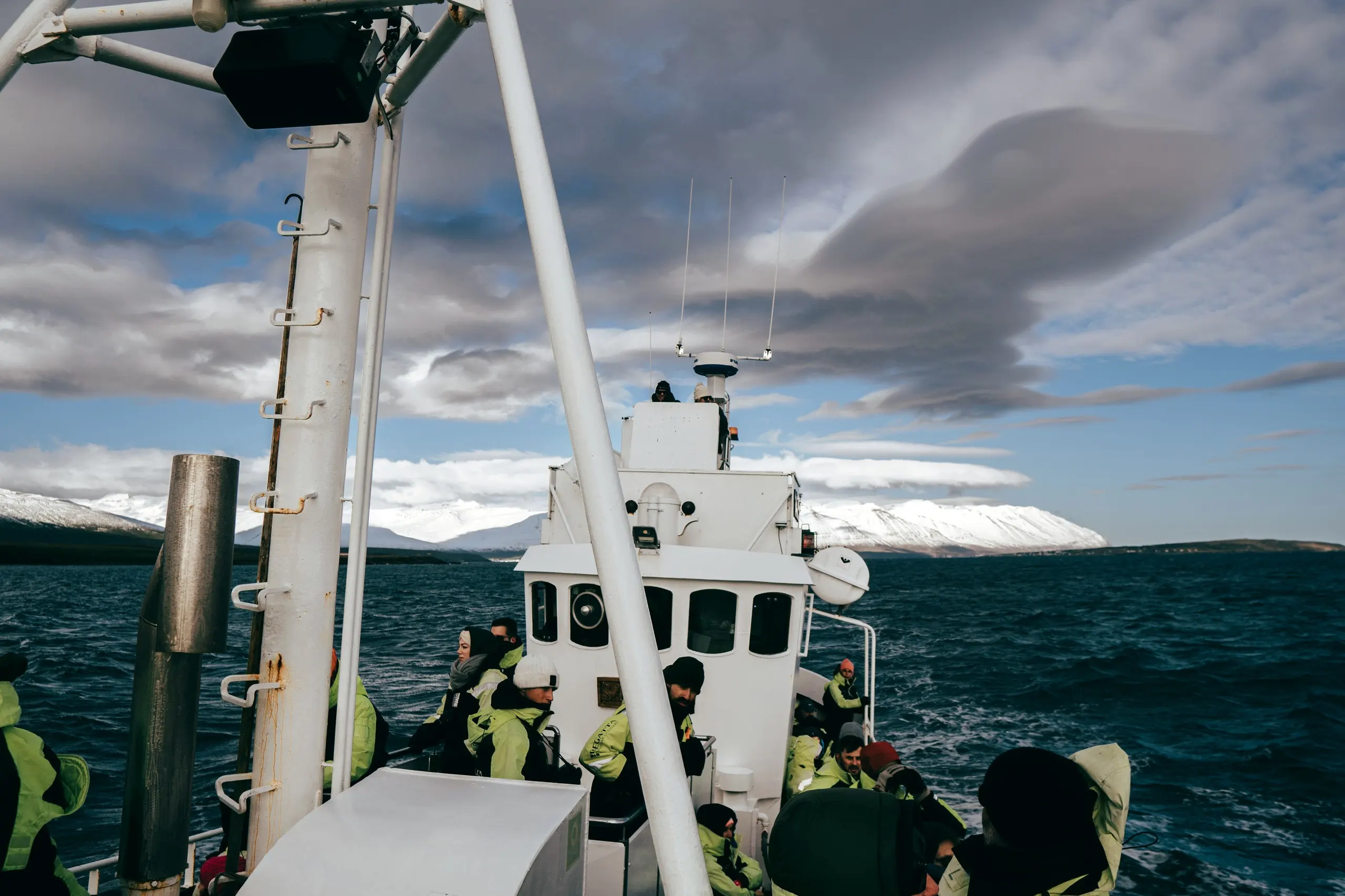 A small boat carrying passengers across a calm Arctic fjord