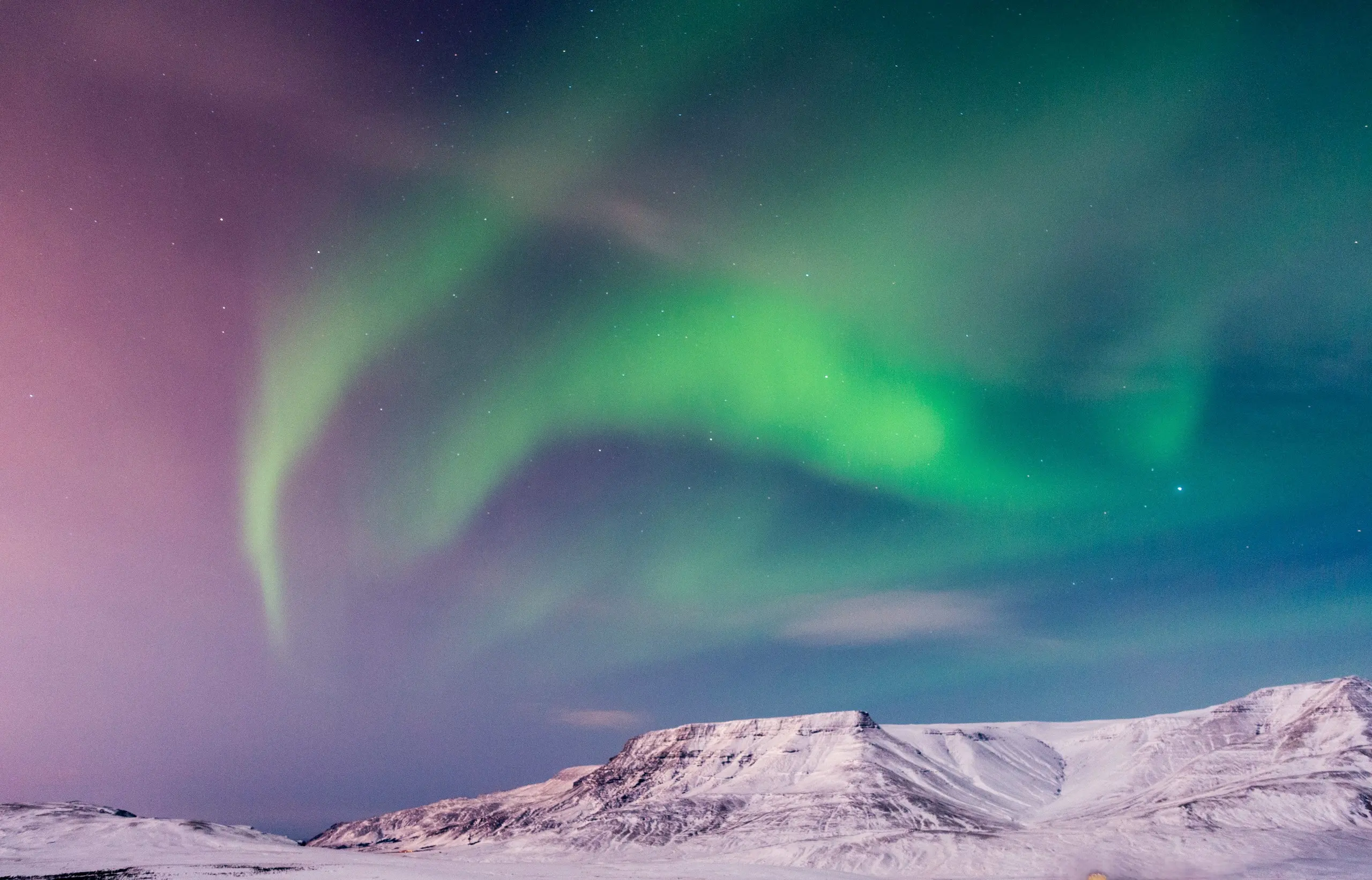 Aurora borealis over snowy Arctic peaks